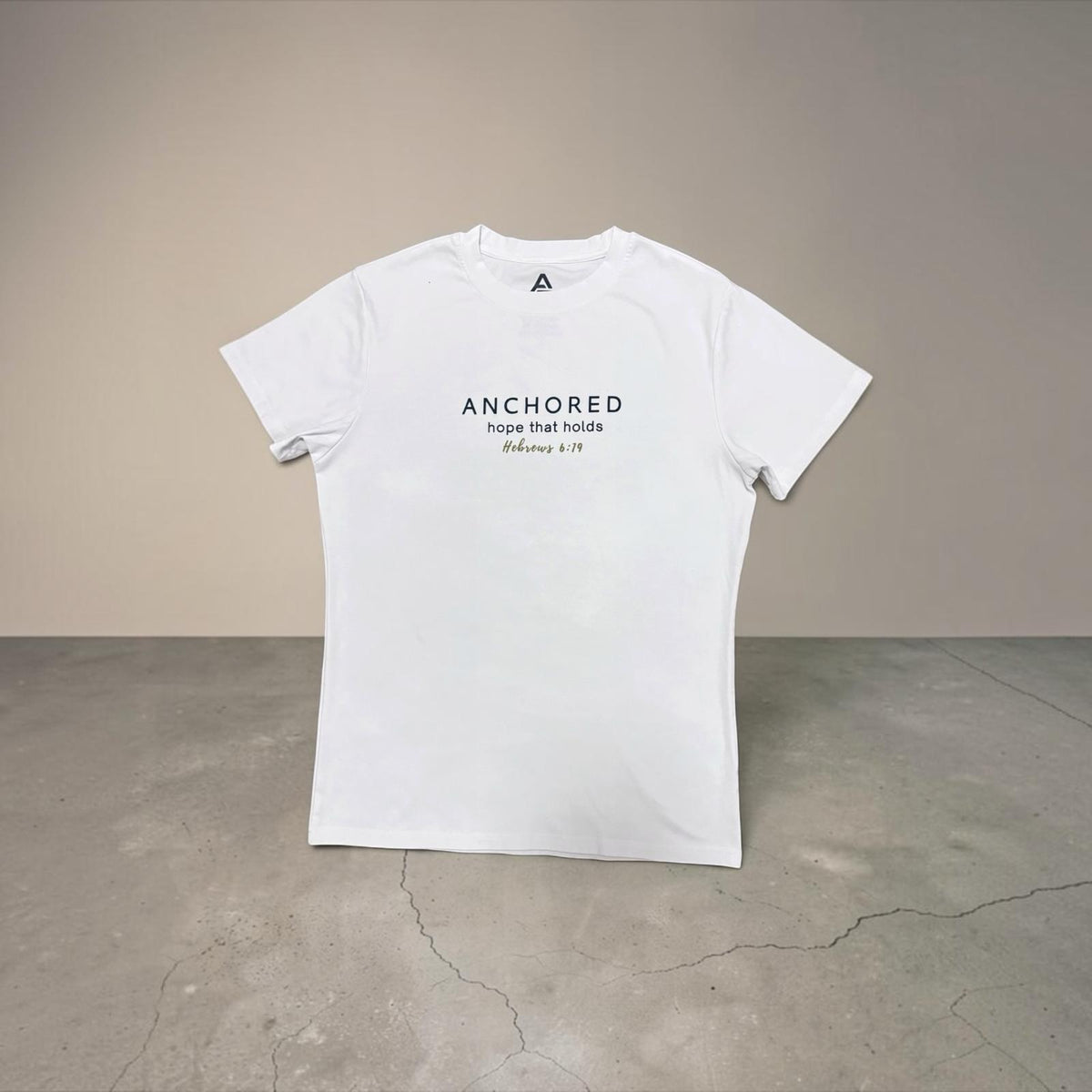 White Anchored men's shirt by ADM Driven featuring the message “Hope that holds,” inspired by Hebrews 6:19, displayed against a neutral background.